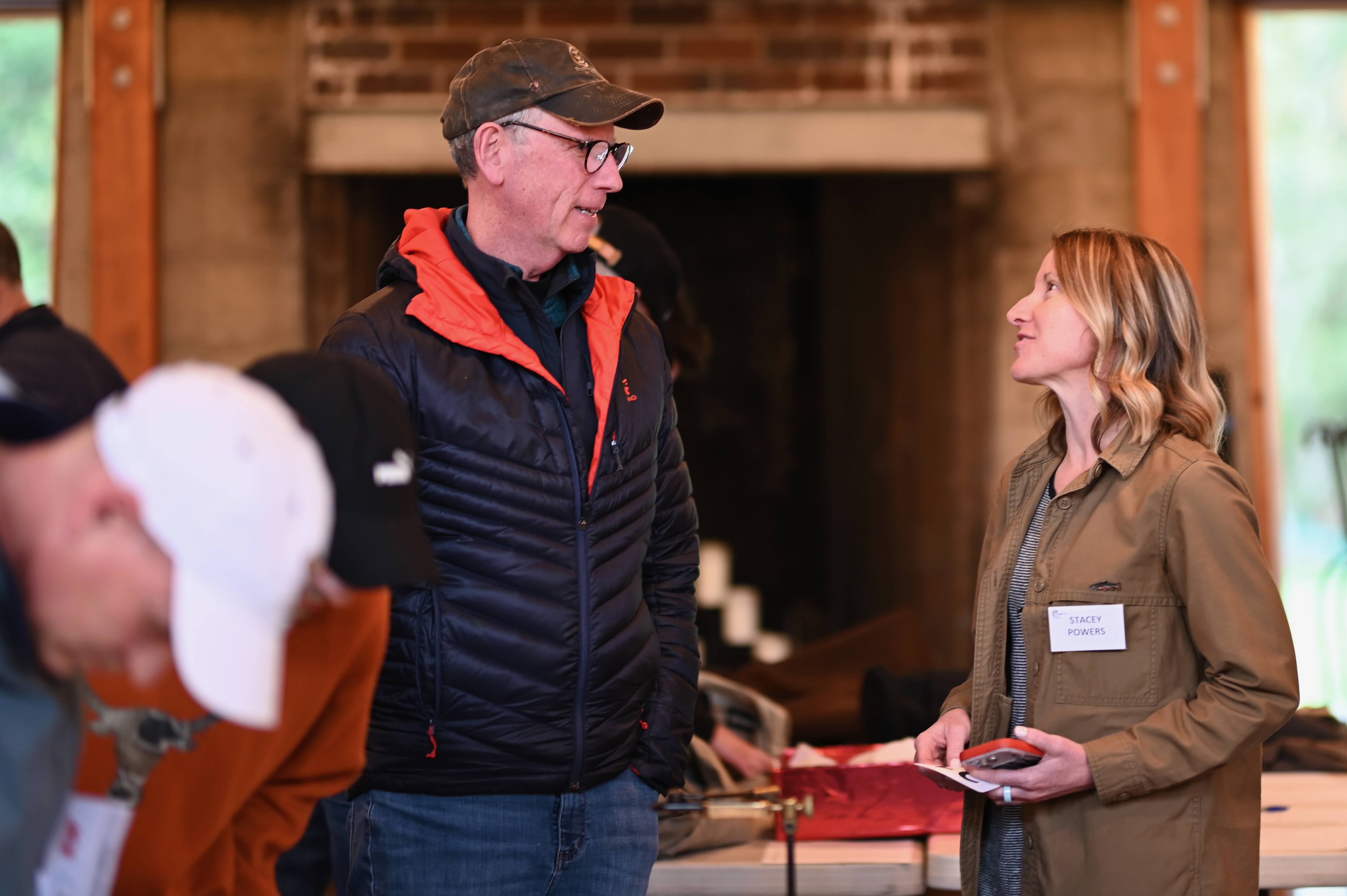 Stacey Powers speaking with a member at an event
