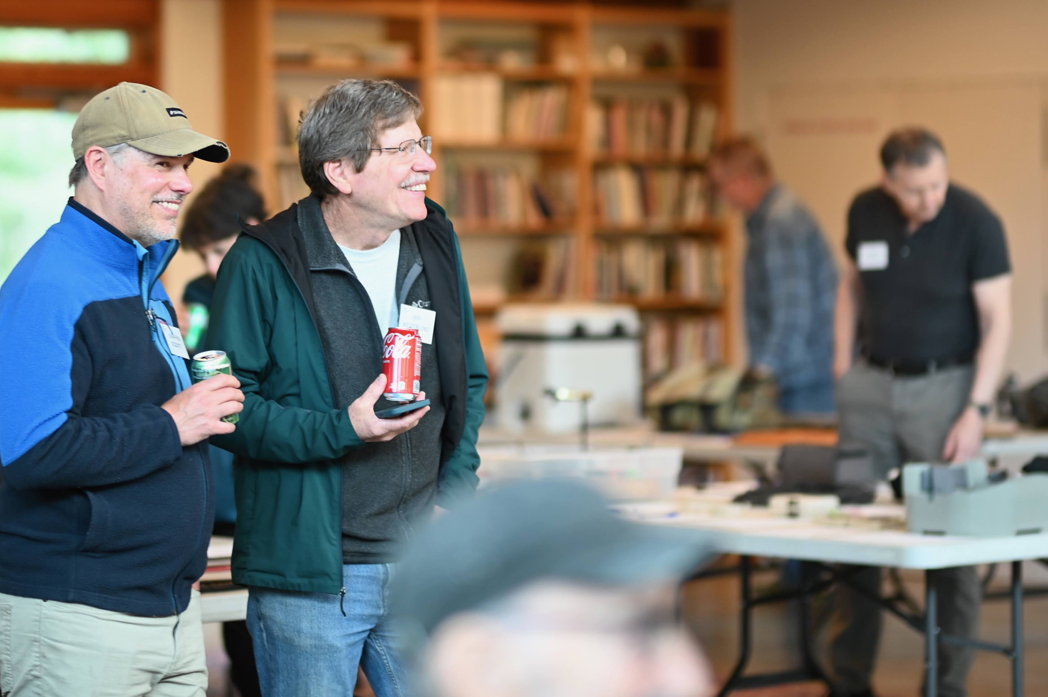 Two members holding beverages at a gathering