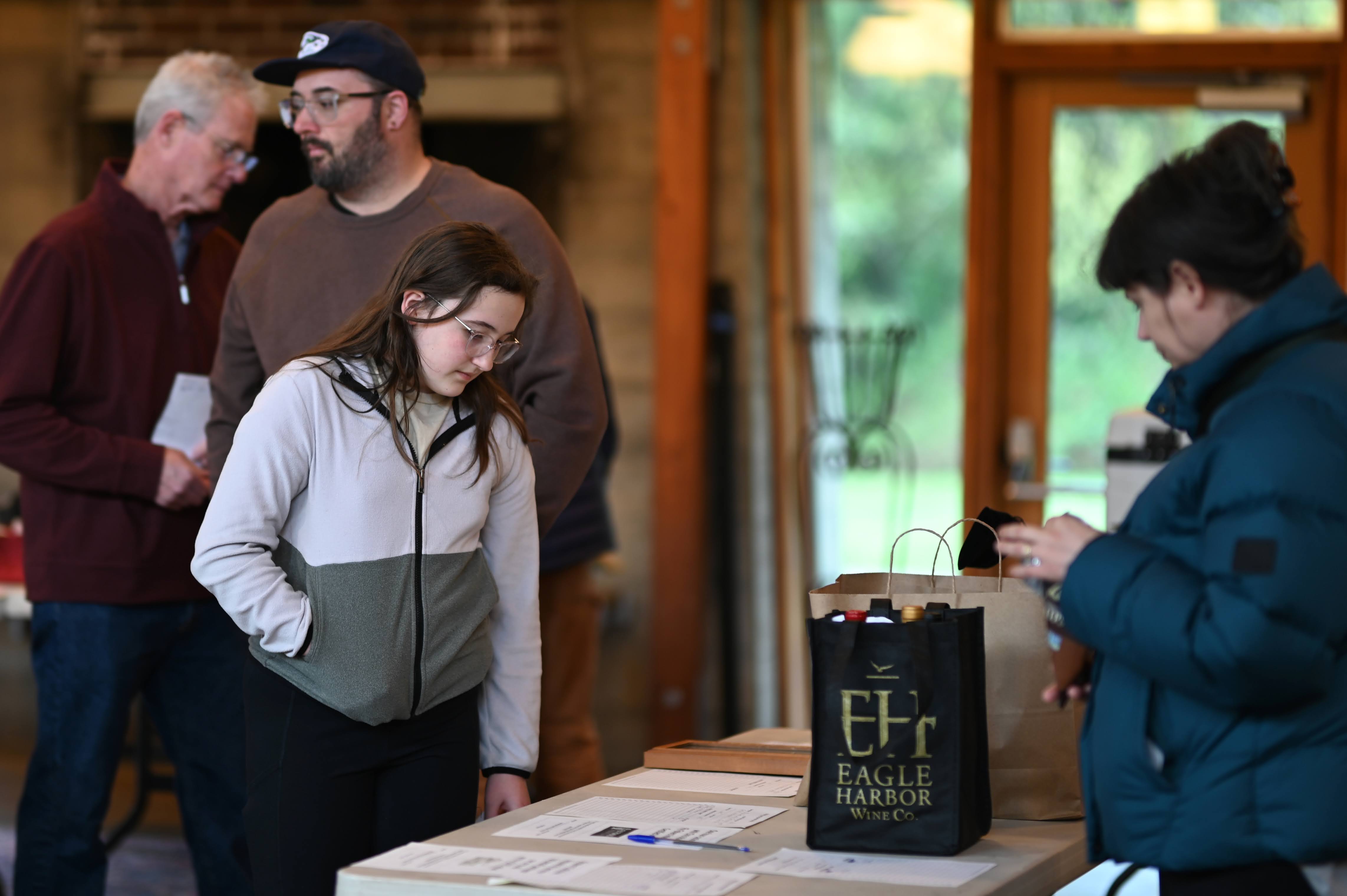 A member at a table with an Eagle Harbor Wine Co. shopping bag